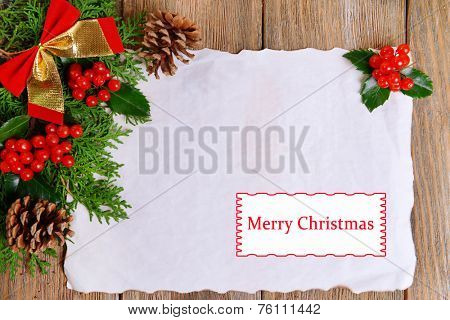 Christmas decoration with paper sheet on wooden background