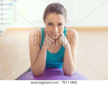 Smiling Woman Exercising At Gym With Fitness Ball