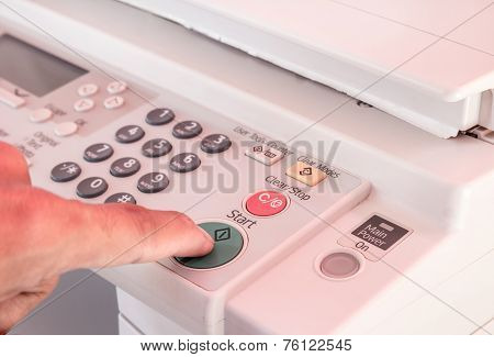 Hand Pressing Start Button On Copy Machine