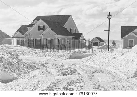 Poor visibility with strong winds blowing snow around during a snow storm in suburbia.