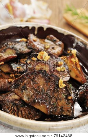 an earthenware bowl with rovellons or niscalos, typical autumn mushrooms in Spain, sauteed with garlic and parsley