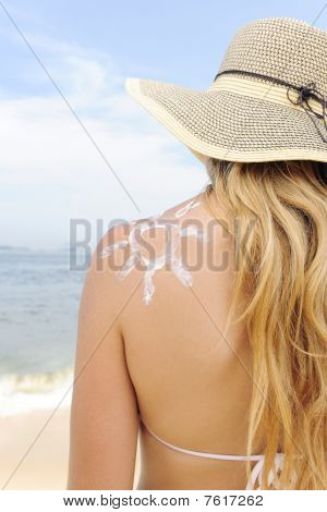 Kvinde med solcreme på stranden