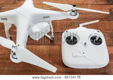 Fort Collins, CO, USA - March 17, 2015:  DJI Phantom 2 quadcopter drone with a radio controller against rustic wooden wood table