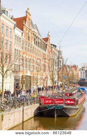 Tourists Walking By A Canal In Amsterdam