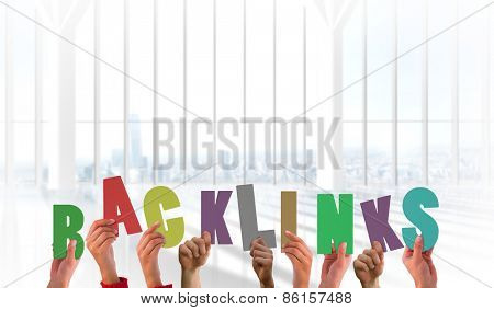 Hands holding up bank links against white room with large window overlooking city