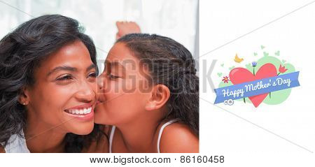 mothers day greeting against pretty woman lying on bed with her daughter kissing cheek