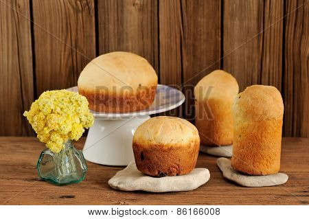 Paska, East European Easter Sweet Breads With Yellow Flowers On Wooden Background