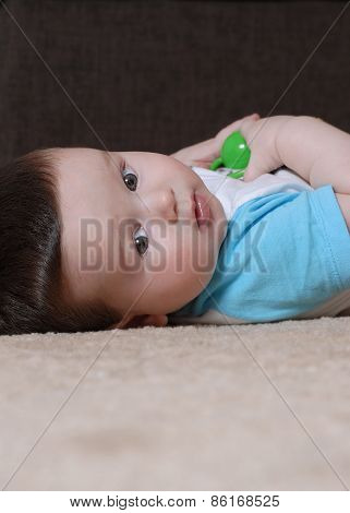 Baby boy lying on the floor looking to camera