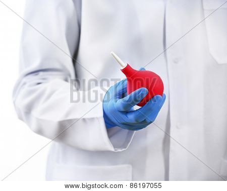 Doctor hand in gloves with medical pink enema syringe isolated on white background