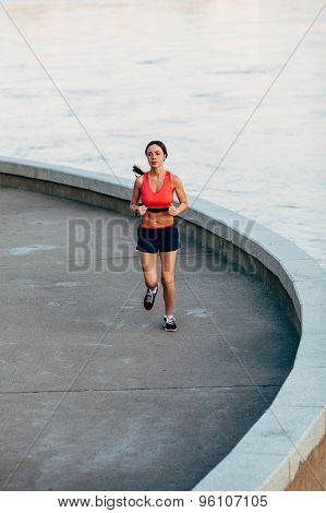 woman runnning along granite curved parapet