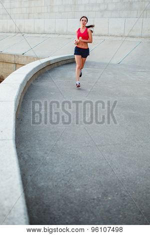 woman runnning along granite curved parapet