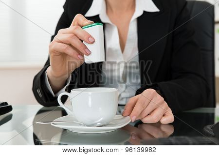 Close-up Of Businesswoman Putting Sugar In Cup