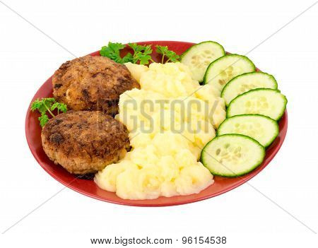 Cutlets with puree and cucumbers on the plate isolated.