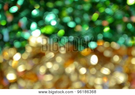 Bright and abstract blurred green and golden background with shimmering glitter