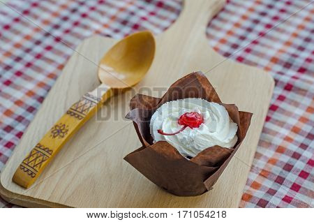 Closeup cake with cherries and cream cheese. Composition in the Russian style on a wooden Board with a traditional spoon.