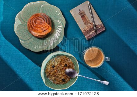 Breakfast on flower-like crockery shooted with a cute notepad with a vintage lighthouse print