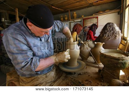 Kinik, Turkey - March 21, 2010: Master potter and his students in studio are working.