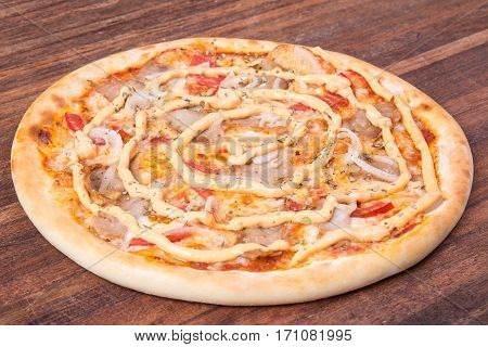 Hot pizza slice with melting cheese on a rustic wooden table.