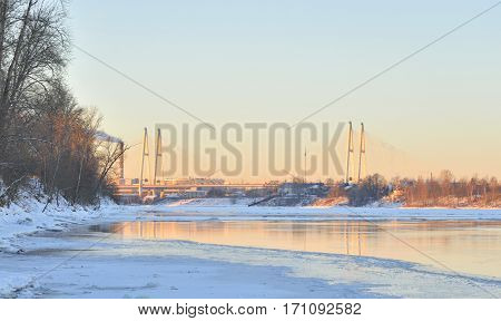 Coast of Neva River and Cable stayed bridge on the outskirts of St. Petersburg at sunny winter evening Russia.
