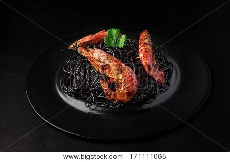 Black Spaghetti With Shrimps On A Black Background With Copy Space.