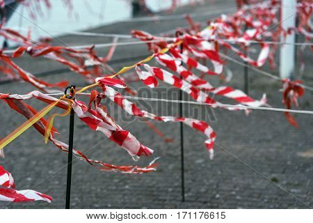 Barrier tape of plastic with red and white stripes luttering in the wind selected focus narrow depth of field