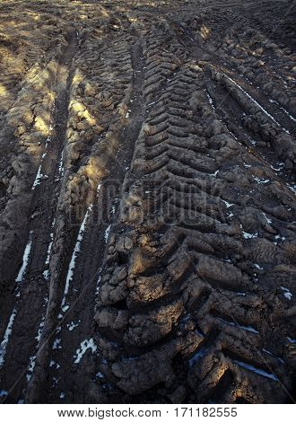 tractor tracks on the frozen field agriculture background texture of the topsoil copy space