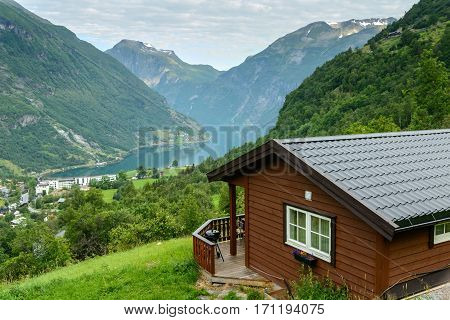 Beautiful view at fiord in a summer day with wooden cabin at foreground, Norway