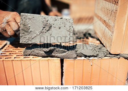 Details Of Industrial Bricklayer Installing Bricks On Construction Site