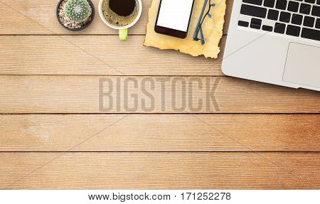 Laptop comuter old paperglasses with cup of coffee and smart phone on wooden desk. Hand typing on a keyboard