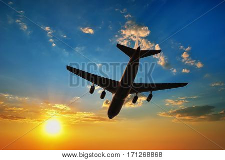 Airplane silhouette in sunset sky. Airplane travel
