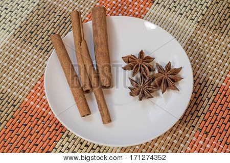 Cinnamon sticks with star anise on white saucer