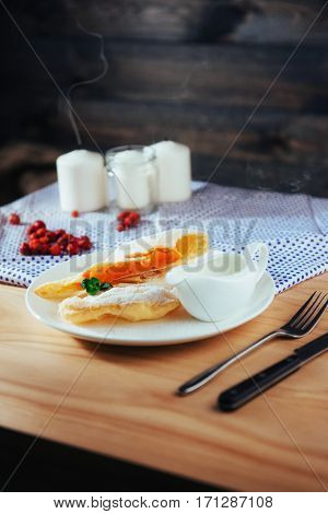 piece of freshly baked pumpkin strudel home with powdered sugar and cream and a sprig of mint