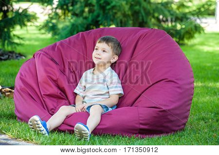 excited kid having fun on bean bag at summer or sping park outdoors.