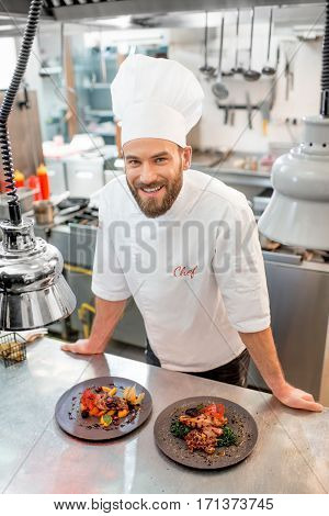 Portrait of chef cook in uniform with prepaired delicious dish at the restaurant kitchen
