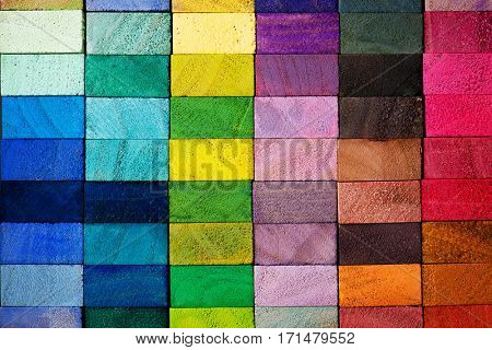 Spectrum of multi colored wooden blocks aligned. Background or cover for something creative or diverse.
