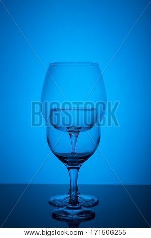 Two empty wine glass on blue background