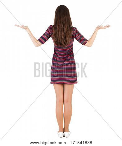 Back view of Beautiful woman in  dress looking at wall and Holds a hand up. Rear view people collection.  backside view of person.  Isolated over white background. skinny girl is holding something