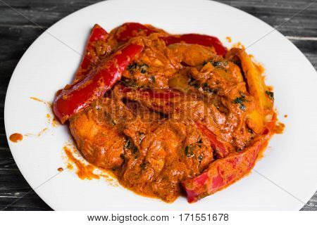 Bigus with chicken breast and bell pepper on a wooden table in rustic style