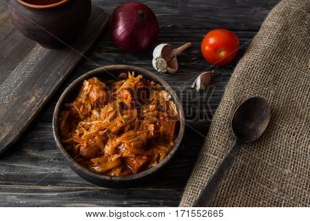 Bigus with sausages in a wooden bowl on a rustic background