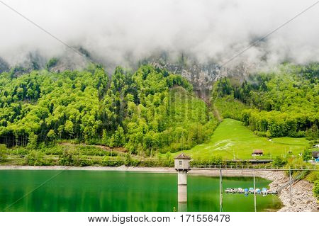 Beautiful emerald mountain lake Lungern in Switzerland under low clouds
