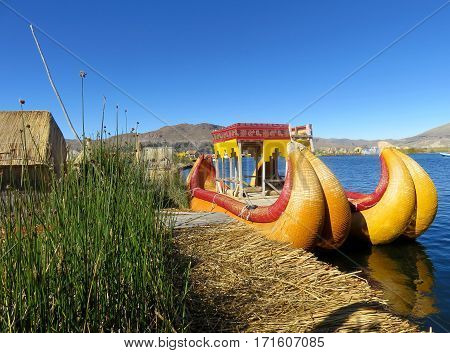 A Colorful reed boat next to a floating island on Lake Titicaca