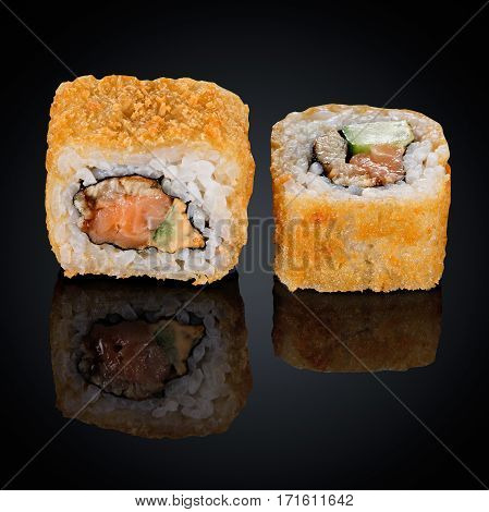 Hot roll with eel, cucumber and cream cheese on a black background