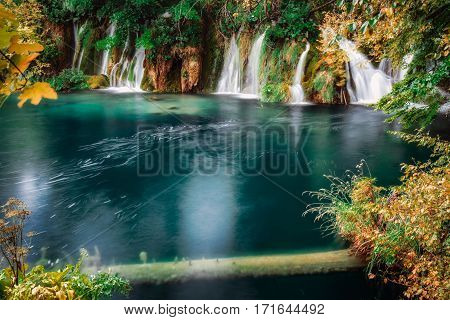 Long exposure waterfall falling to emerald lake at Plitvica, Croatia.