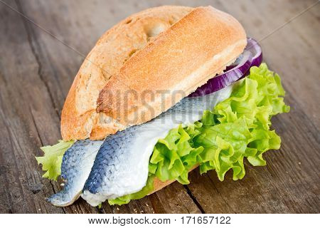 herring in a bun on wooden table