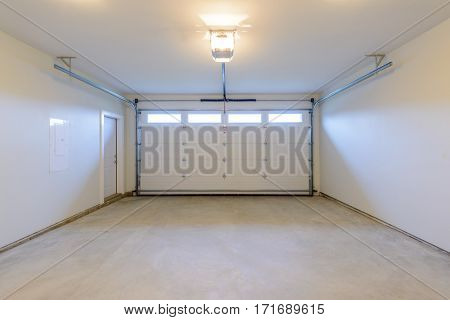 An empty garage with door and windows.