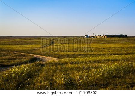 House in the desert the road to it. Peaceful rural landscape.