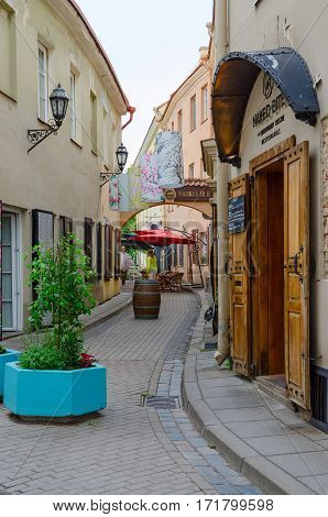 VILNIUS LITHUANIA - JULY 10 2015: Unknown people go near restaurant Naked Bite of Contemporary Cuisine on Stikliu Street in Old Town Vilnius Lithuania