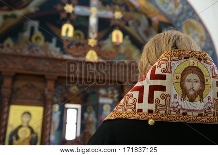 Orthodox bishop praying in front of altar icons
