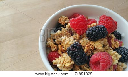 A bowl filled with berries, granola and yogurt.