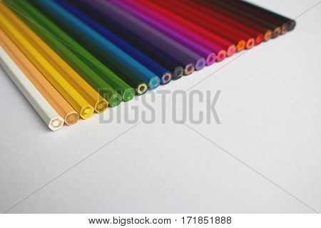 A row of colored pencils arranged chromatically.